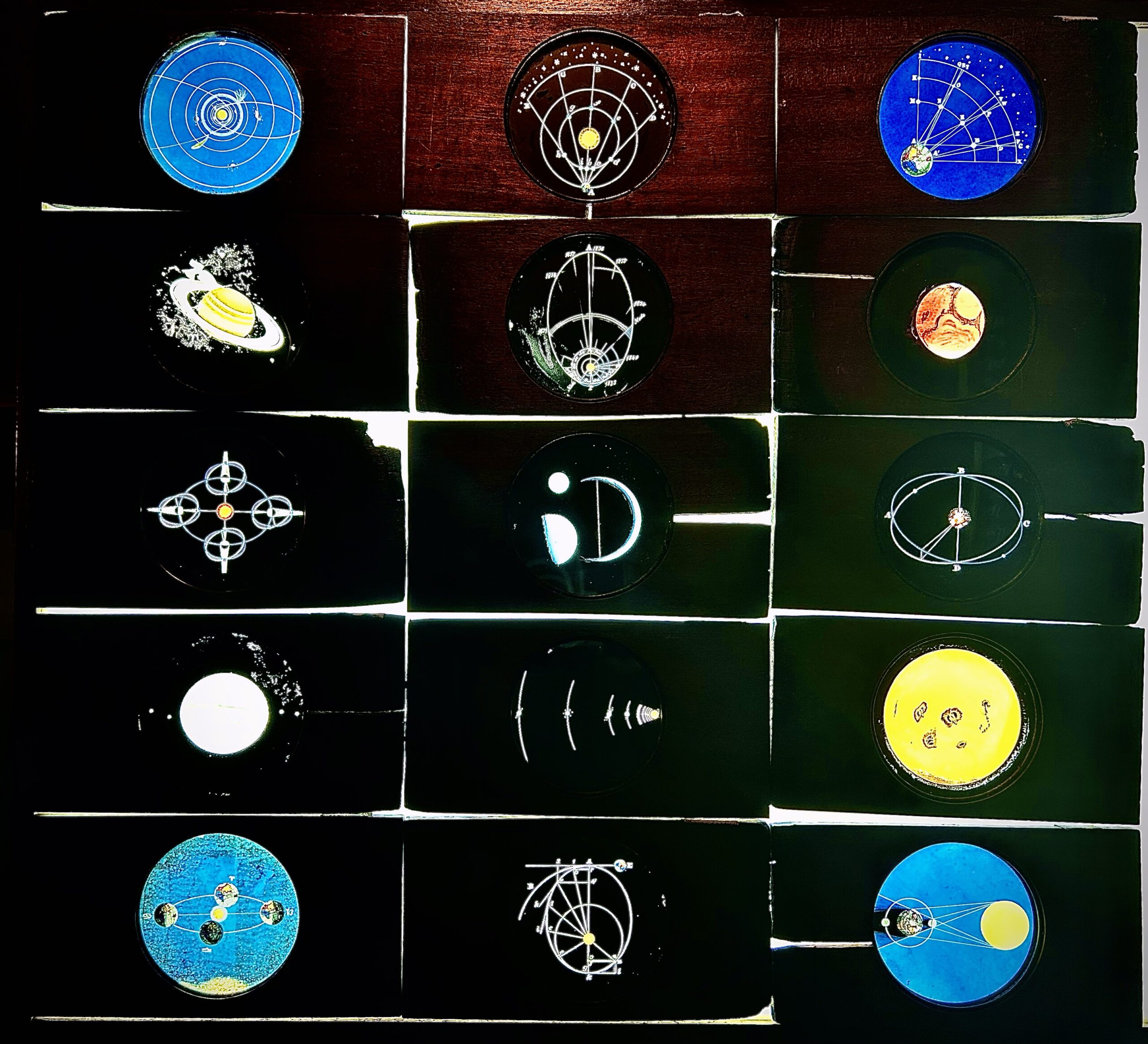 Hand-painted magic lantern slides of the solar system, which featured in Tesseract (2013)